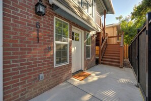 A brick house with a white door, a wooden staircase, and a metal gate. - Urban Oasis in the Heart of Sacramento! (Sacramento)