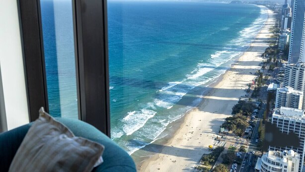 A high-rise building with a view of a beach and ocean. - Oceanfront Escape! 2 Beds Home w/ Gym  & Carpark (Surfers Paradise)