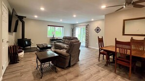 Un salon spacieux avec une cheminée, un coin repas et un ventilateur de plafond.