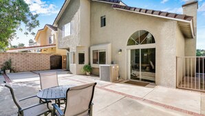 A house with a patio, outdoor seating, and a large window.
