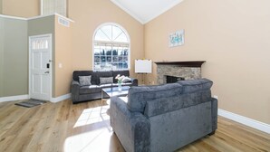 A spacious living room with a fireplace, a large window, and a door.
