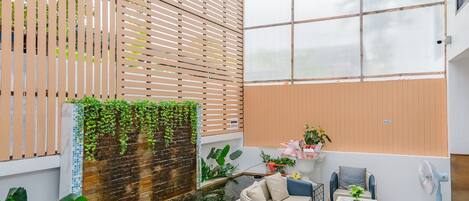 A modern indoor space with a seating area, a water feature, and a large window.