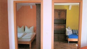 A room with a bed, a sofa, and a cabinet. - Apartment 'Ferienwohnung Stadermann' with Private Terrace, Private Garden and Balcony (Walow-Strietfeld)