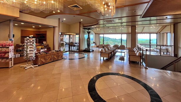 A spacious lobby with a high ceiling, a central chandelier, and a seating area with a view of the outdoors. - Hikosan Hotel Nagomi (Soeda)