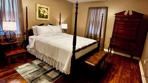 A bedroom with a four-poster bed, a wooden dresser, a nightstand, a lamp, and a ceiling fan. - Charming 3-bedroom, spacious home conveniently located near Tuskegee University (Tuskegee)