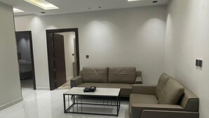 Una sala de estar moderna con un sofá modular, una mesa de centro y piso de baldosas.