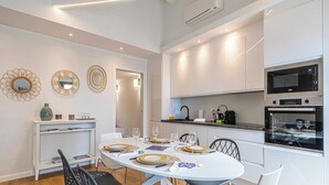 Une cuisine moderne avec des meubles blancs, un four encastré et un four à micro-ondes.