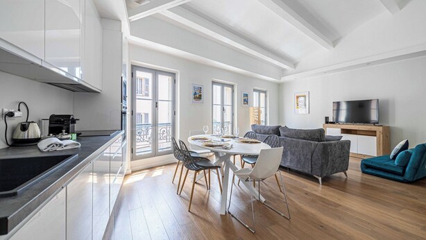Un appartement moderne comprenant une cuisine, un coin repas et un salon.