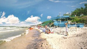 A beach with boats, people, and a clear sky. - Comfortable Holiday Homes With Terraces (Postomino)
