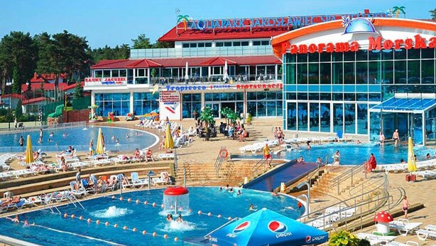 A swimming pool area with multiple pools, a restaurant, and a large building with a red roof. - Comfortable Holiday Homes With Terraces (Postomino)