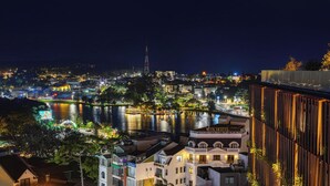 Ein Hotel mit Blick auf einen Fluss und das Stadtleuchten bei Nacht.