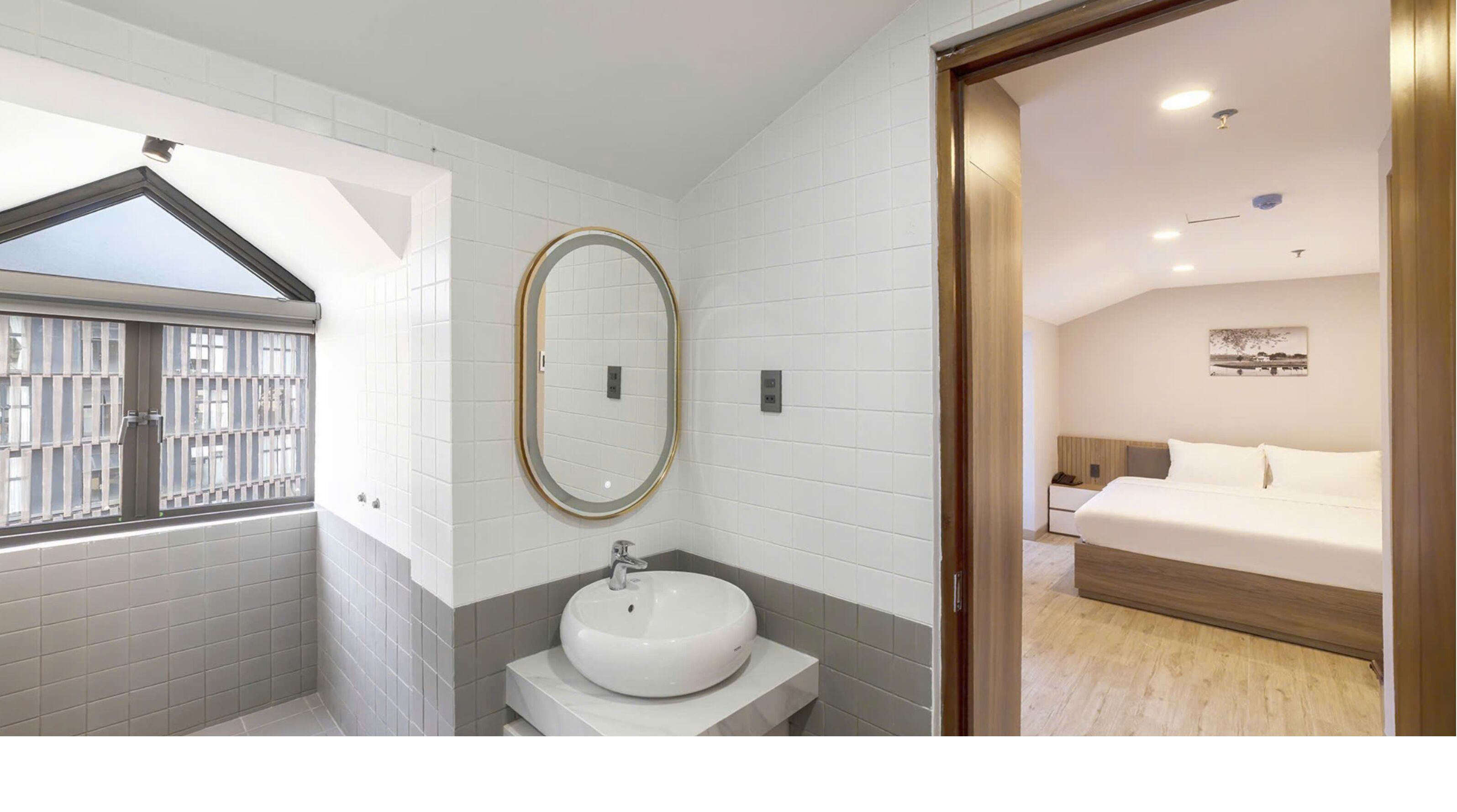 Un baño moderno con un ventanal grande, un espejo redondo y un lavabo.