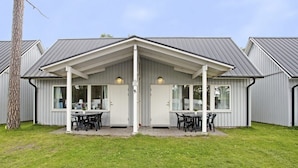 A two-story building with a covered patio area, large windows, and a metal roof. - Ystad Camping (Ystad)