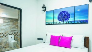 Ein Hotelzimmer mit einem Bett, einem Nachttisch, einer Wandlampe und einem großen Fenster.