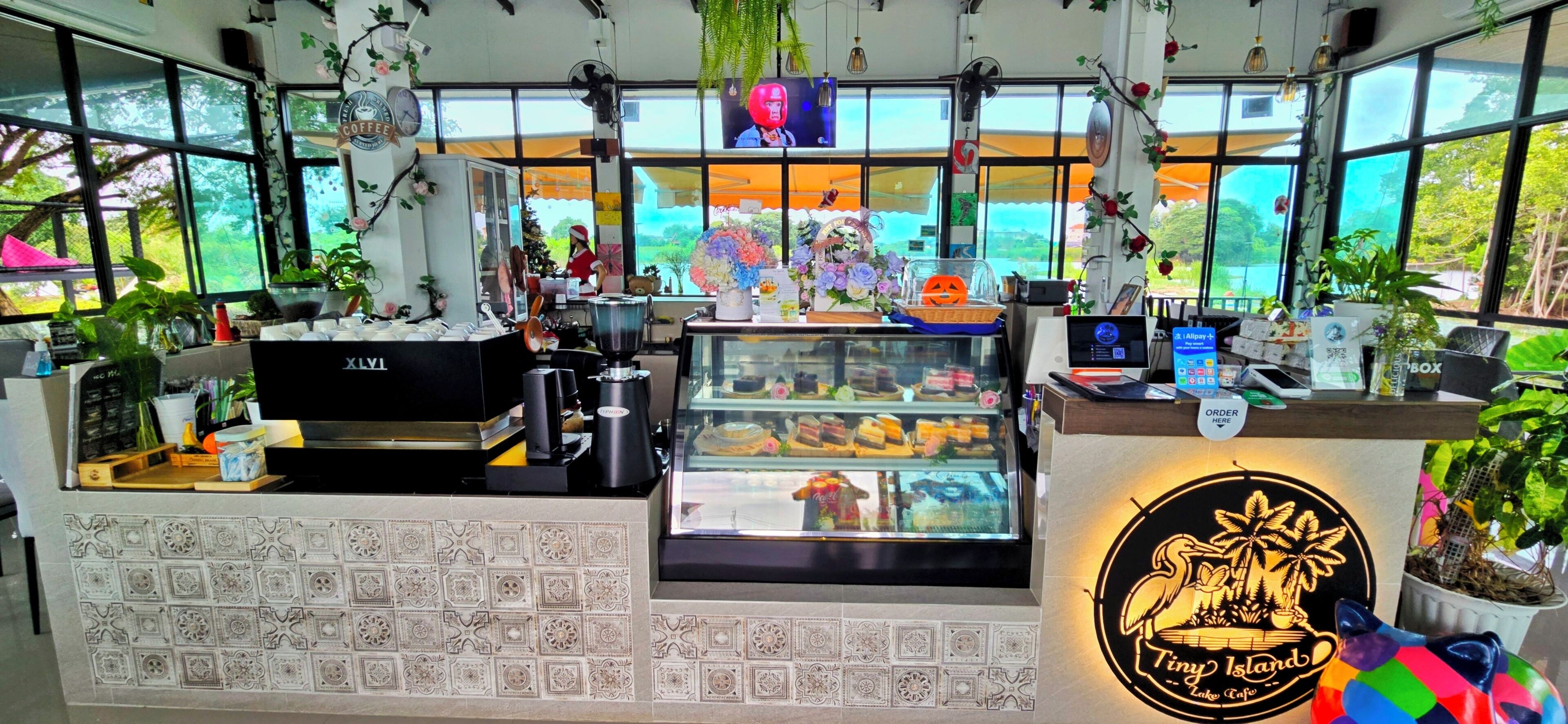 A coffee shop interior with a counter, display case, and various coffee-making equipment.