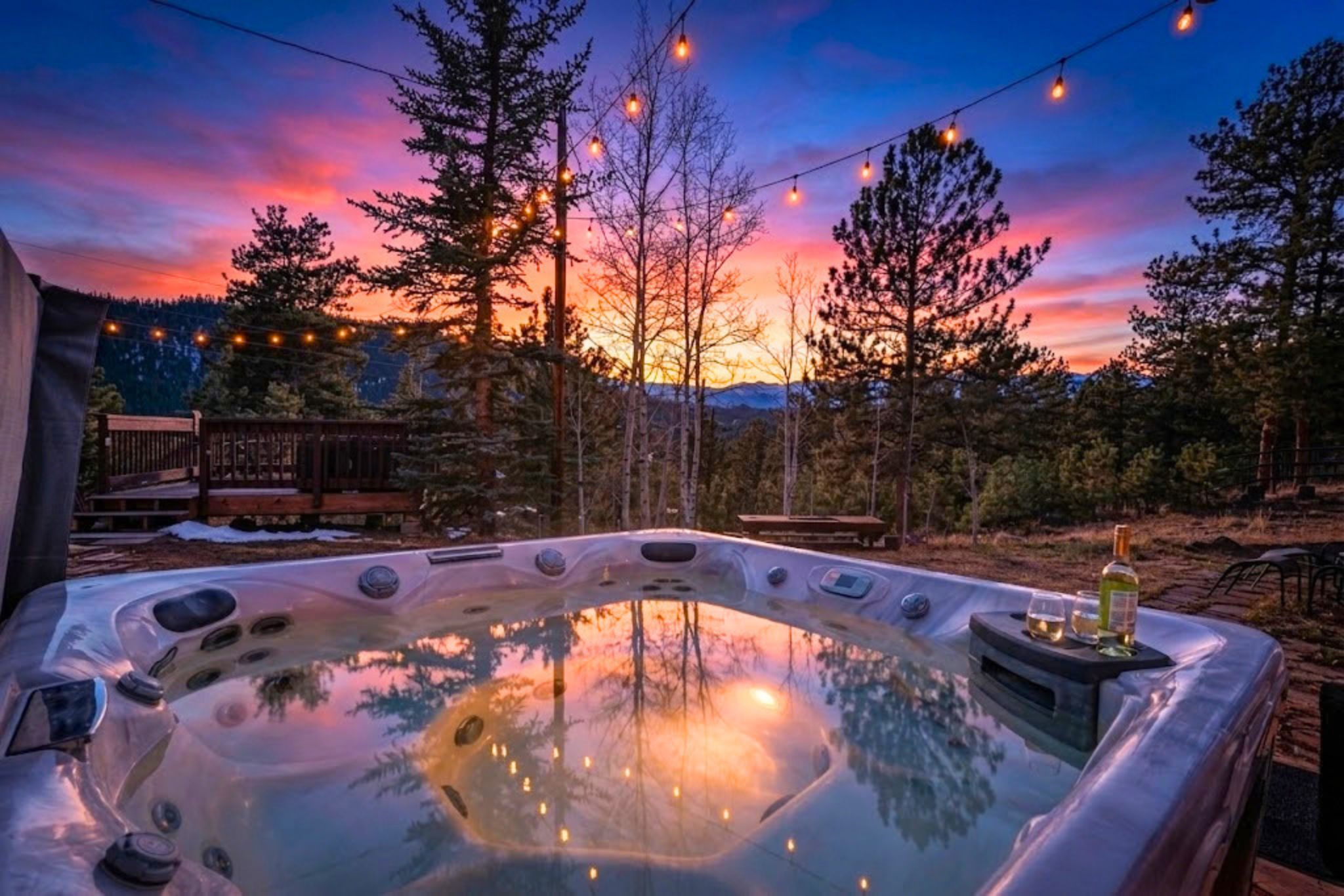 A hot tub with a view of a sunset and trees.