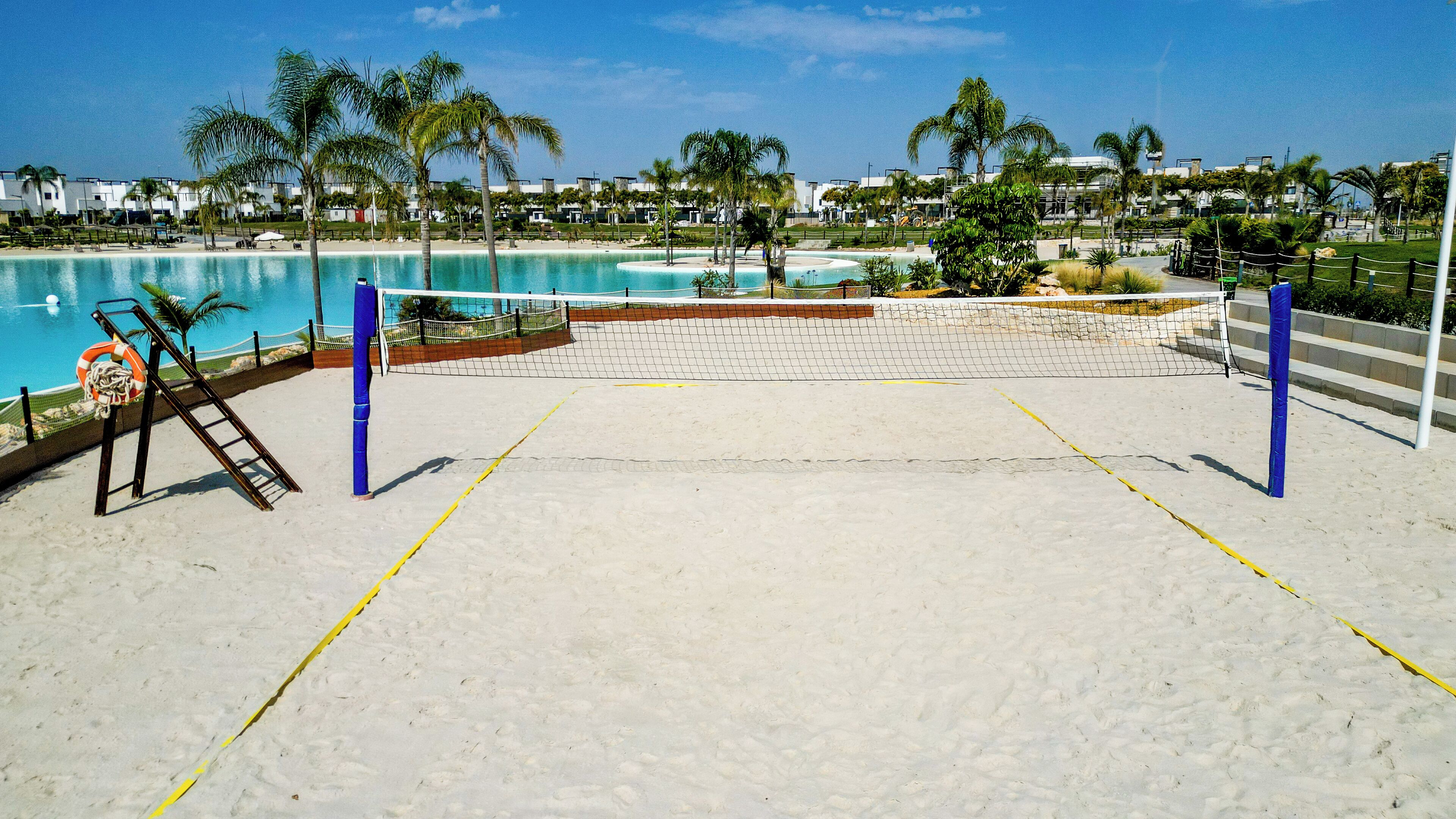 Camp de voleibol platja amb xarxa, un bou salvavides i una escala.