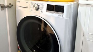 A front-loading washing machine with a yellow basin on top, ENERGY STAR label, and a control panel with various settings.
