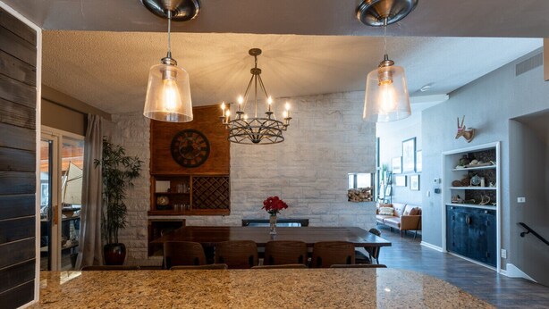 A spacious kitchen with granite countertops, a central island, and pendant lighting. - Historic home w/ indoor pool on Iconic 8th St (Fargo)