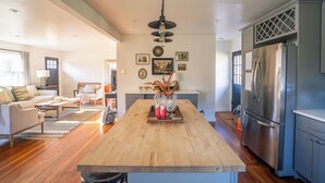 A spacious kitchen with a wooden island, stainless steel appliances, and a dining area with a sofa and coffee table.