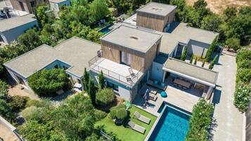 Un complexe résidentiel moderne comprenant plusieurs maisons individuelles, une piscine et des jardins bien entretenus.