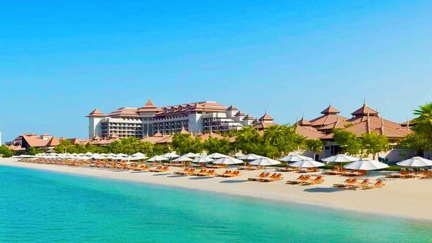 A beachfront hotel with multiple buildings, a sandy beach, and numerous umbrellas. - Palm Jumeirah, Studio, Fantastic sea, beach and skyline view, Beach  (Dubai)