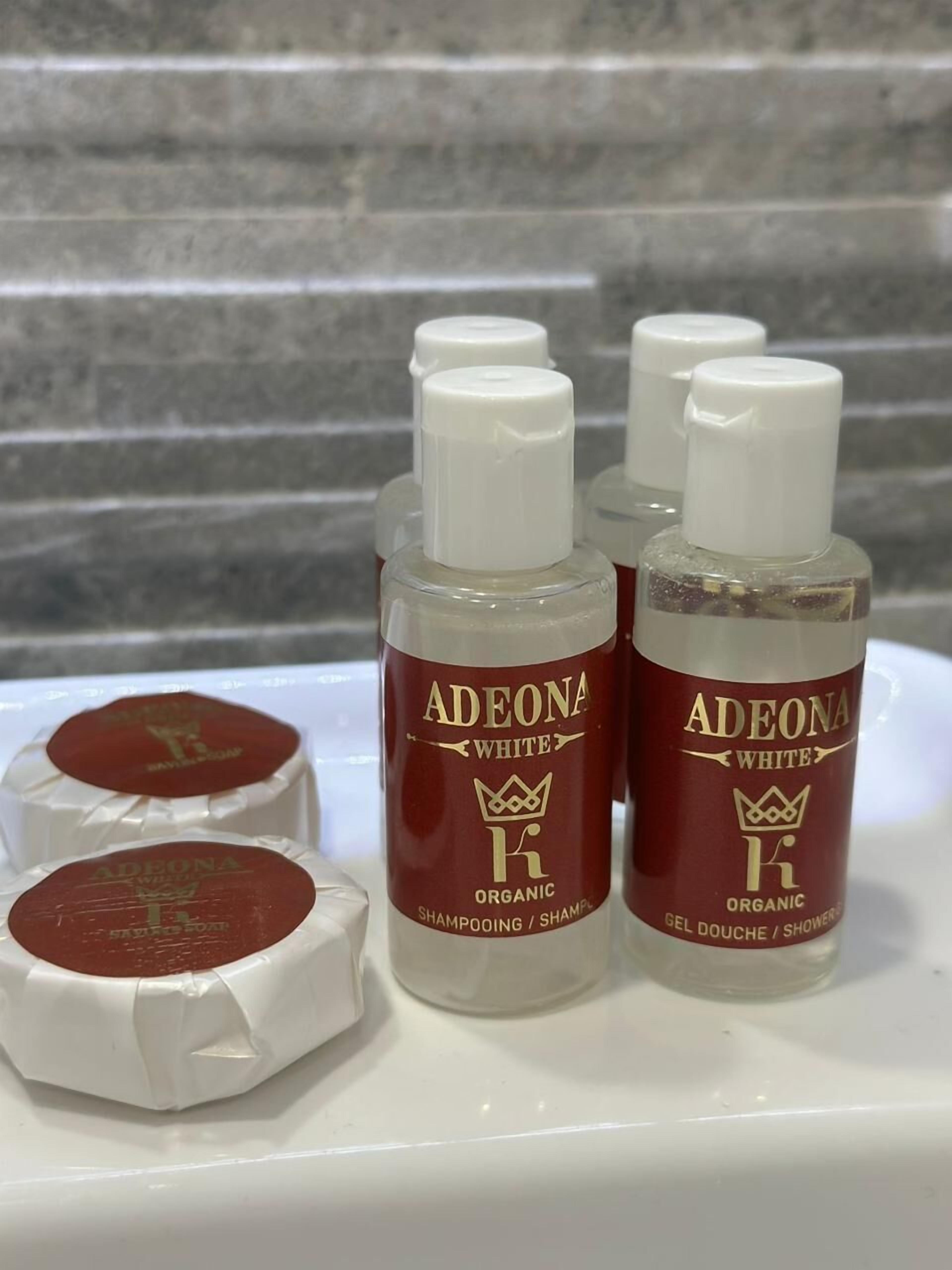 Vier flessen Adeona White biologische shampoo en gel op een witte ondergrond.