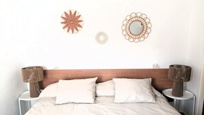 A bed with a wooden headboard, two bedside tables with lamps, and decorative wall art.