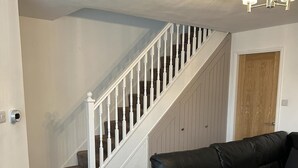 A staircase with white balusters and a beige carpeted floor. - Tranquil Sheffield Retreat - 3 Bedroom House (Sheffield)