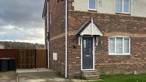 A two-story brick house with a dark front door, a small porch, and a window with blinds. - Tranquil Sheffield Retreat - 3 Bedroom House (Sheffield)