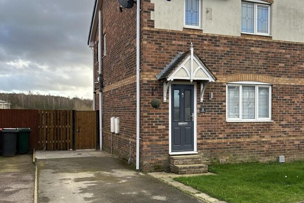 A two-story brick house with a dark front door, a small porch, and a window with blinds. - Tranquil Sheffield Retreat - 3 Bedroom House (Sheffield)