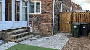 A residential property with a brick exterior, a wooden gate, and a small front yard with artificial grass and gravel. - Tranquil Sheffield Retreat - 3 Bedroom House (Sheffield)