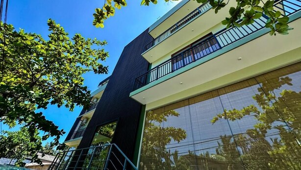 Un immeuble moderne à plusieurs étages, doté de balcons et de grandes fenêtres.