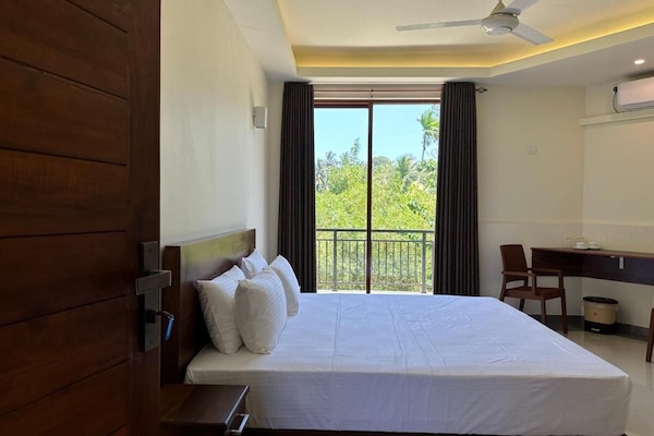 Habitación Deluxe doble, varias camas, balcón, vistas a la ciudad | Mobiliario individual, escritorio, tabla de planchar con plancha