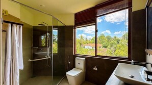 Une salle de bain moderne dotée d’une douche à parois de verre, de toilettes et d’un lavabo.