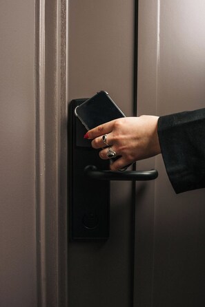 Een hand die een smartphone vasthoudt in de buurt van een slotmechanisme.