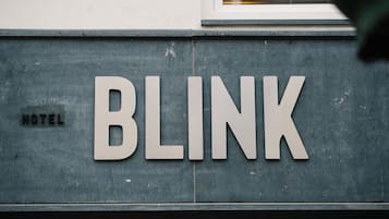 A sign with the word "BLINK" on a building facade.