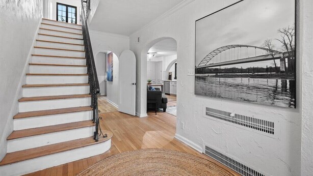 Una escalera conduce a una sala de estar con una fotografía grande en blanco y negro en la pared.