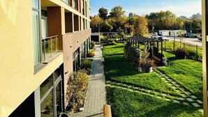 A modern building with multiple balconies, a paved walkway, and a well-maintained garden area. - Joy City Stay Nord One N2-1 (Timișoara)