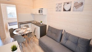 Un espacio habitable compacto con kitchenette, comedor y sofá.