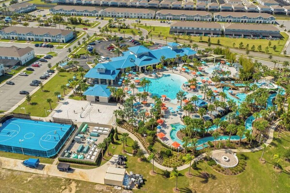 A resort with multiple swimming pools, a tennis court, and a variety of outdoor seating areas.