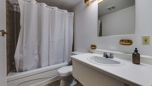 Un baño con ducha, inodoro y lavabo.