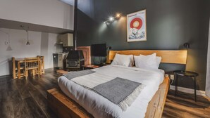 A modern bedroom with a large bed, a wooden headboard, a small table, a TV, and a fireplace. - Studio Courchevel 2 (Mezz 2 Q - 1 DL) - 6 people (Saint-Ferréol-les-Neiges)