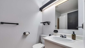 A modern bathroom with a toilet, sink, mirror, and towel rack. - Studio St-Anton 8 (1 Q) - 2 people (Saint-Ferréol-les-Neiges)