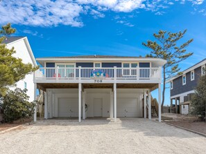 A two-story building with a covered front porch, a garage, and a number '708' on the front. - Fancy Free - Oceanfront 4 BR. (Surf City)