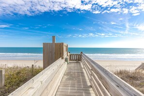 A wooden boardwalk leading to a beach with a clear sky. - Fancy Free - Oceanfront 4 BR. (Surf City)