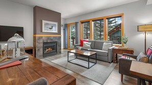Ein Wohnzimmer mit Kamin, einer Couch, einem Couchtisch und einem Fernseher.