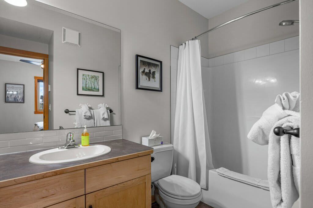 Een badkamer met wastafel, toilet en douche.