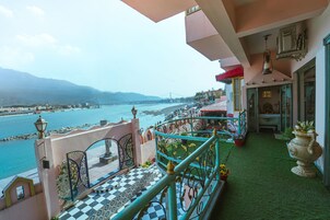 Een balkon met een zwart-wit schachthoekvloer, uitzicht op een rivier en een brug in de verte.