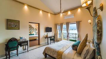 A hotel room with a bed, a desk, a chair, a television, and a balcony with curtains.